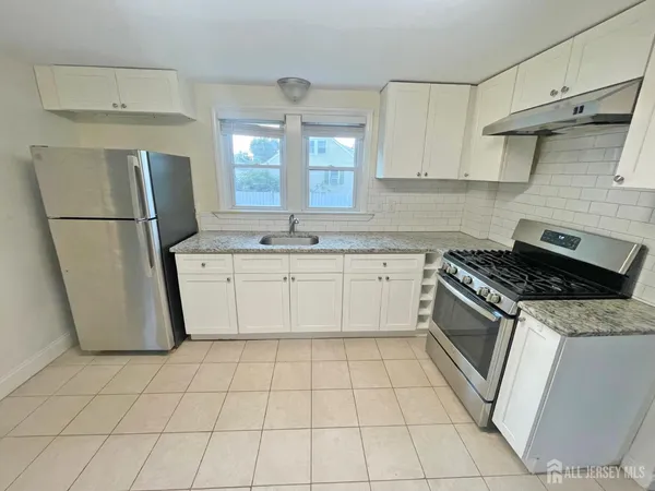 a kitchen with a stove a refrigerator and a sink