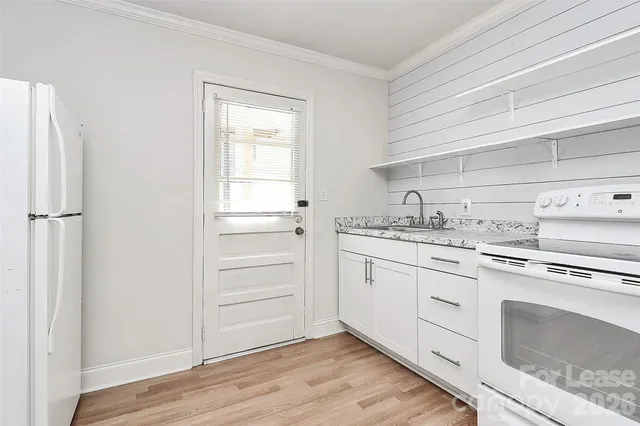 a kitchen with a stove cabinets and wooden floor