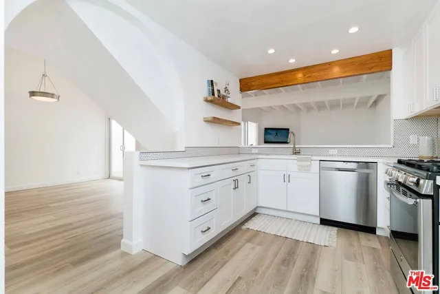 a kitchen with white cabinets and white appliances