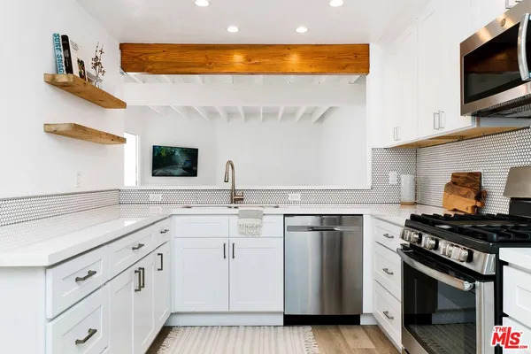 a kitchen with stainless steel appliances a sink stove and cabinets