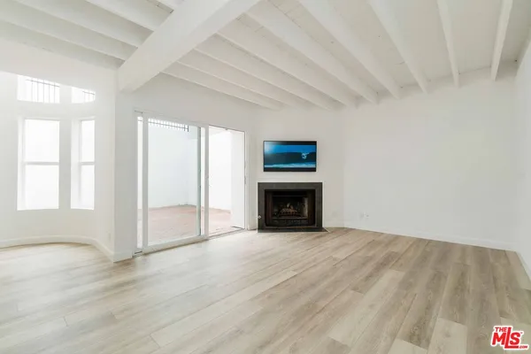 a view of empty room with wooden floor and fireplace