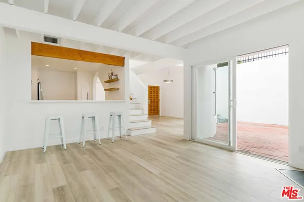a view of a livingroom with wooden floor and a bathroom