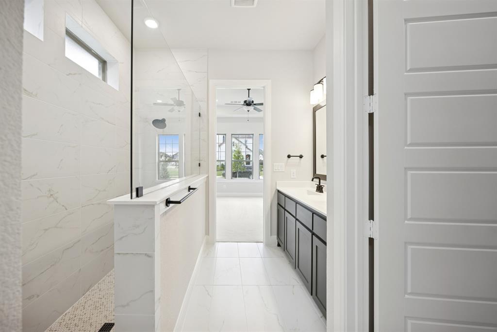 1837 Lightner Road Van Alstyne, TX 75495 - Photo 14 of 30 a bathroom with a double vanity sink a mirror a bathtub and shower