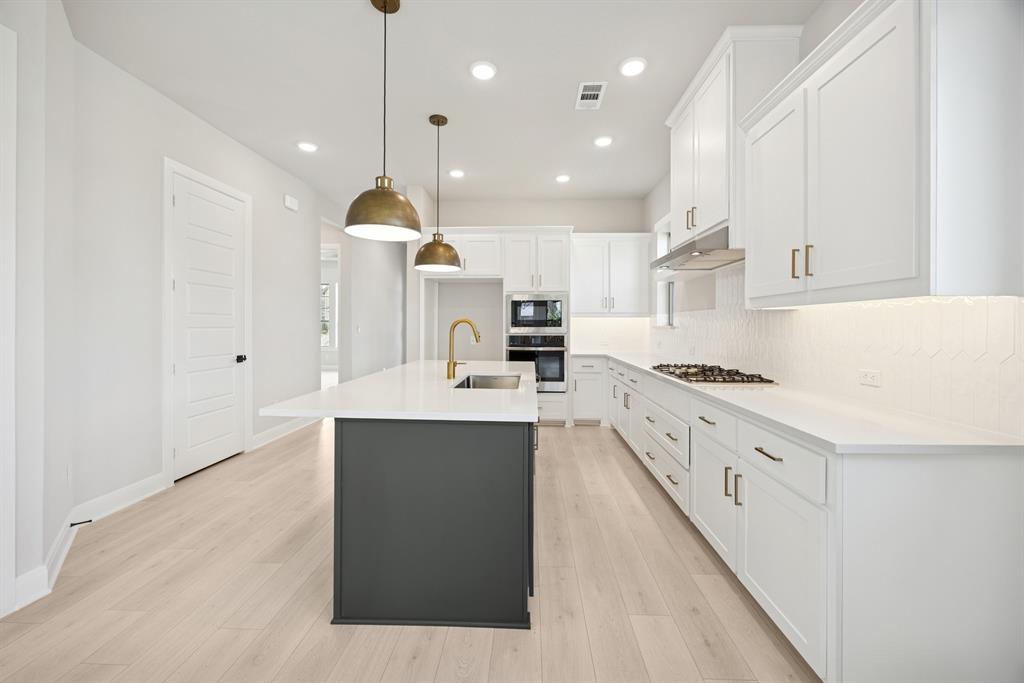 1837 Lightner Road Van Alstyne, TX 75495 - Photo 19 of 30 a kitchen with stainless steel appliances kitchen island granite countertop a sink a stove and a refrigerator