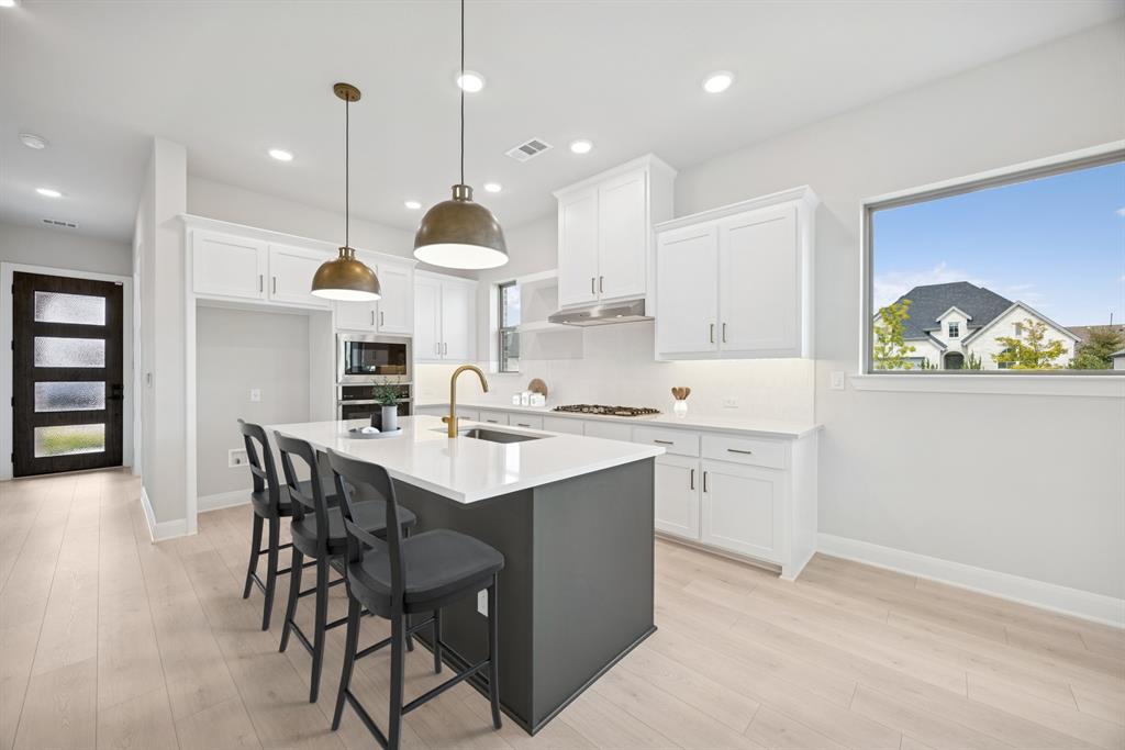 1837 Lightner Road Van Alstyne, TX 75495 - Photo 5 of 30 a kitchen with a sink a center island stainless steel appliances and cabinets