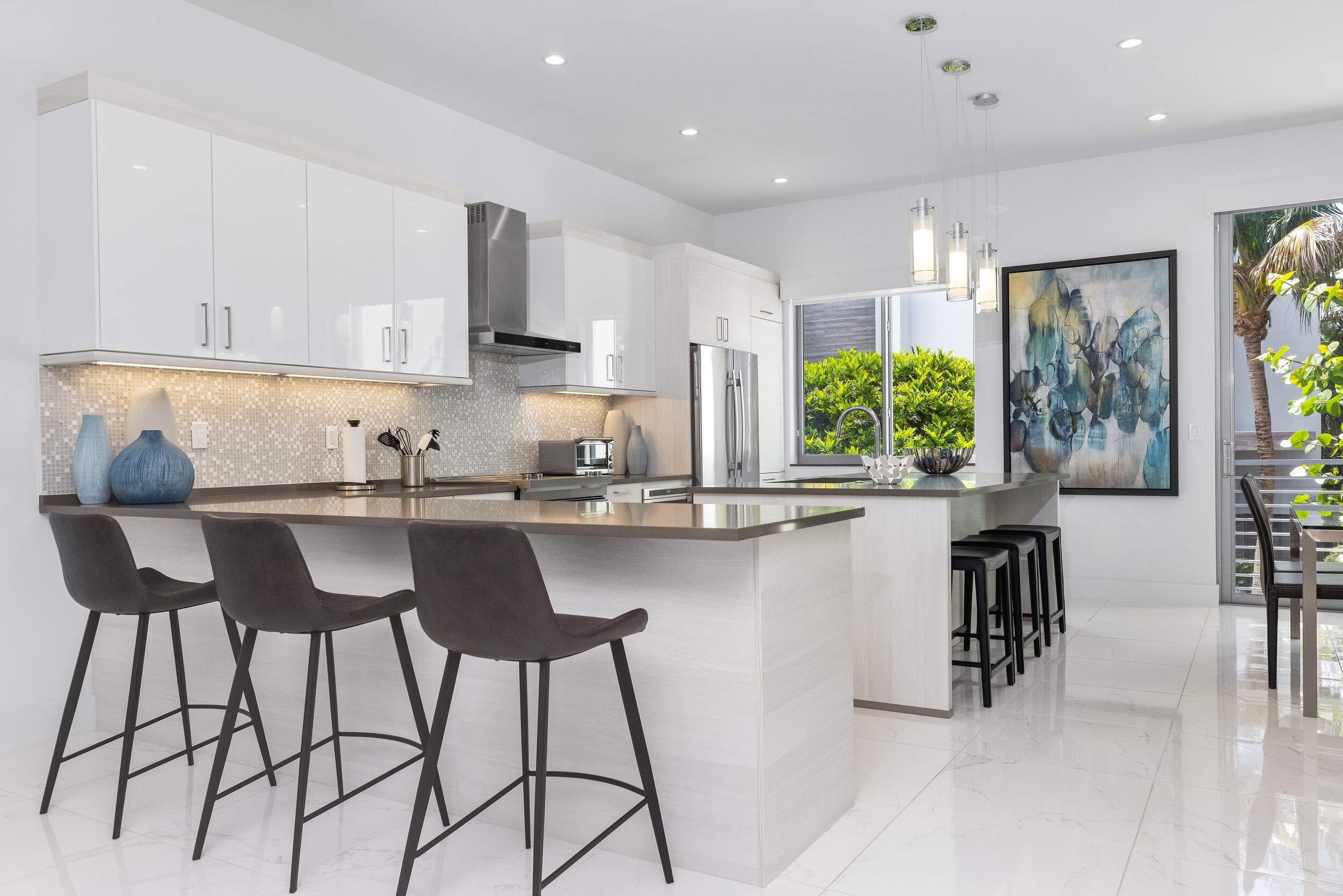 1851 Northwest 40th Drive Boca Raton, FL 33431 - Photo 13 of 42 a kitchen with a table chairs cabinets and wooden floor