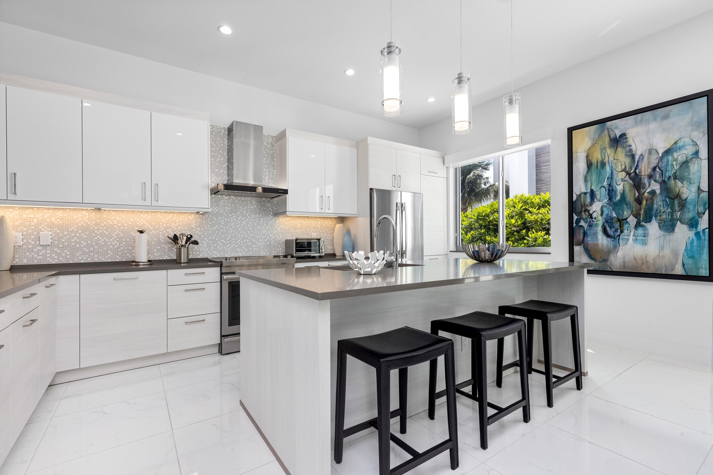 1851 Northwest 40th Drive Boca Raton, FL 33431 - Photo 15 of 42 a kitchen with stainless steel appliances kitchen island granite countertop a stove a sink and a refrigerator