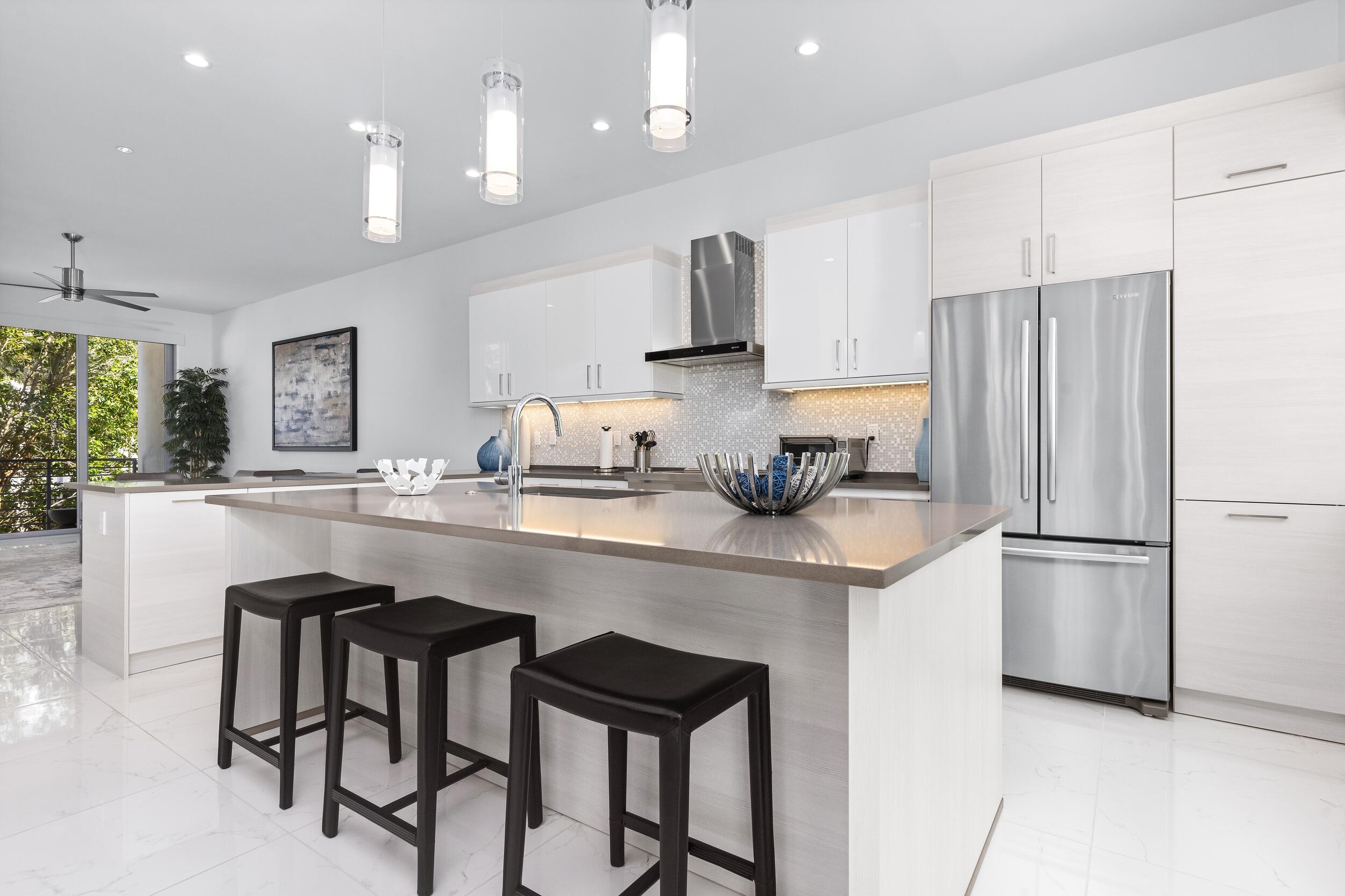 1851 Northwest 40th Drive Boca Raton, FL 33431 - Photo 16 of 42 a kitchen with kitchen island cabinets and refrigerator