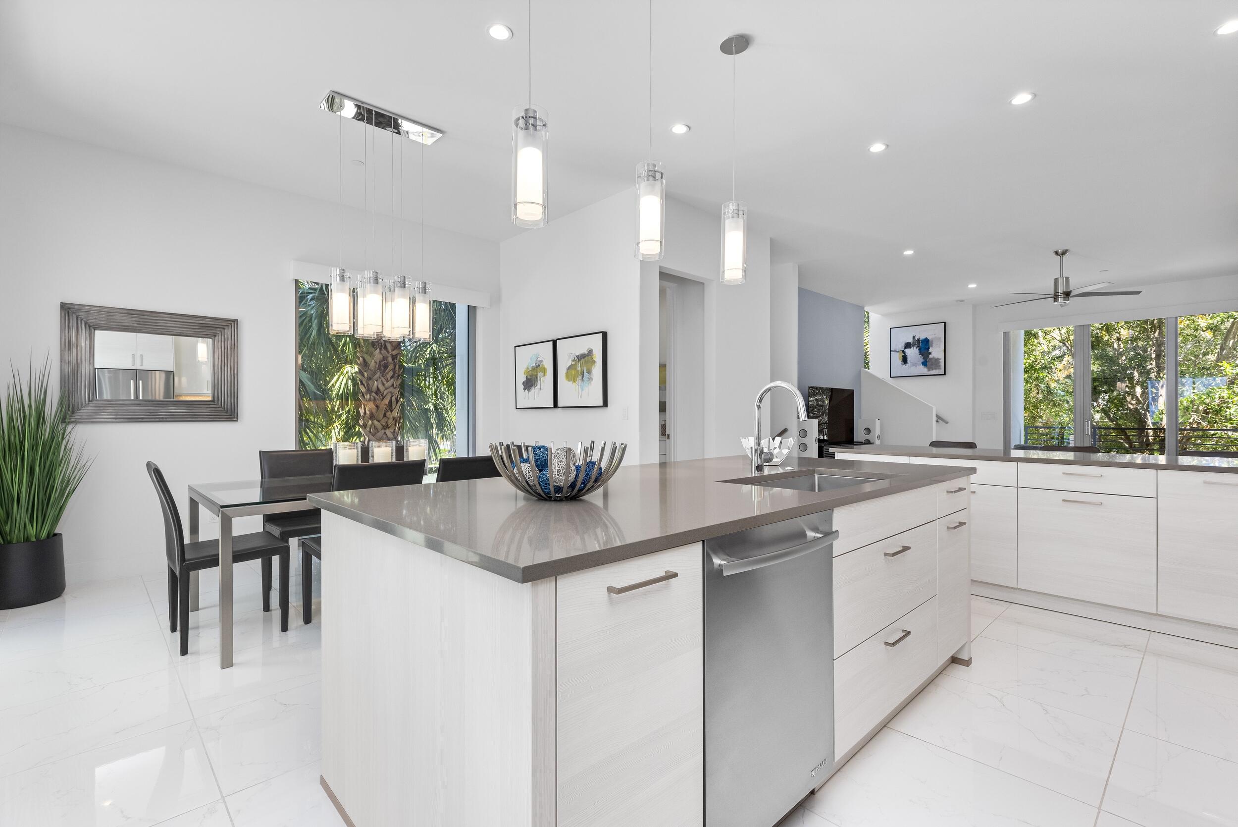1851 Northwest 40th Drive Boca Raton, FL 33431 - Photo 18 of 42 a kitchen with white cabinets and sink