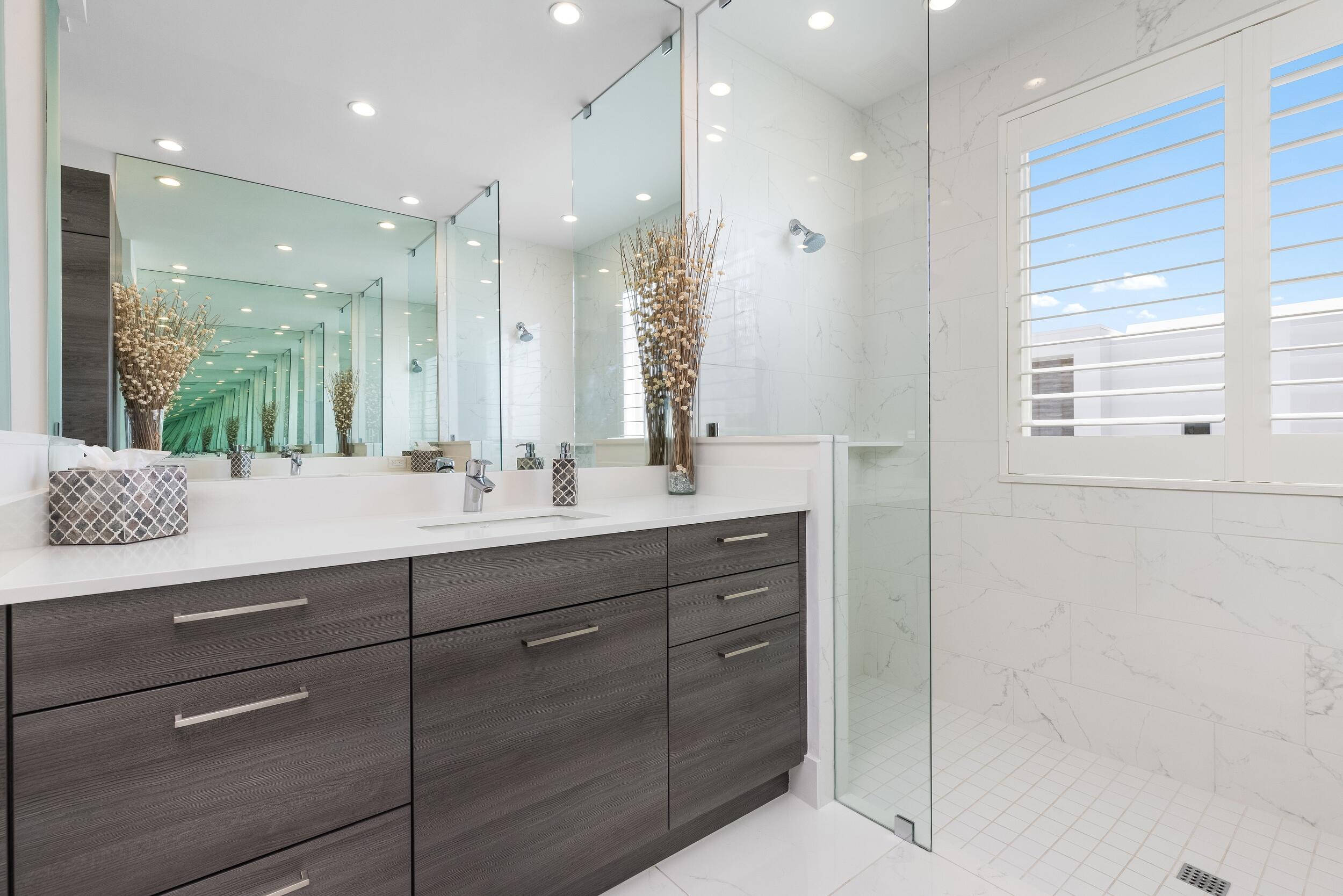 1851 Northwest 40th Drive Boca Raton, FL 33431 - Photo 31 of 42 a bathroom with a double vanity sink a mirror and a shower