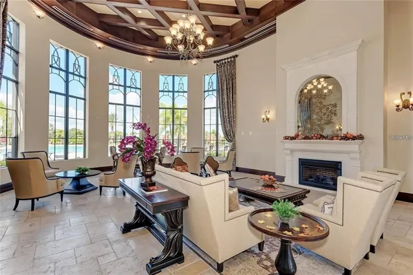 a living room with furniture a chandelier and a fireplace