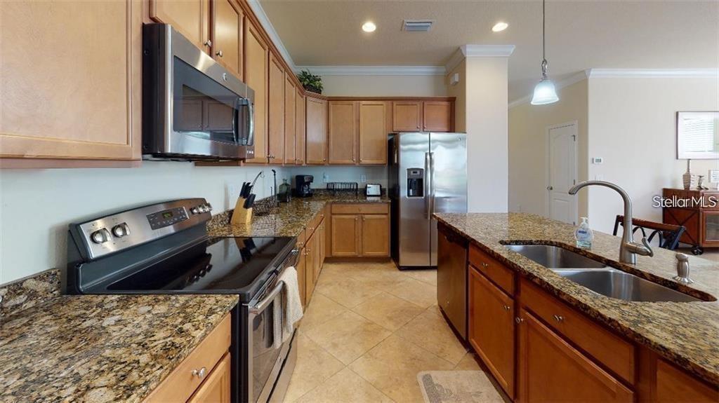 12659 Richezza Drive Venice, FL 34293 - Photo 7 of 42 a kitchen with stainless steel appliances granite countertop a sink stove and refrigerator