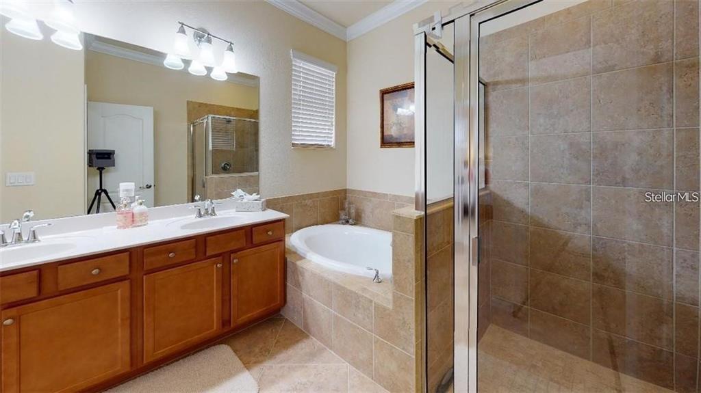 12659 Richezza Drive Venice, FL 34293 - Photo 9 of 42 a bathroom with a tub sink and mirror