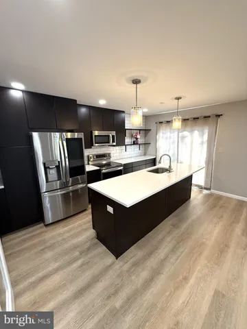 a kitchen with stainless steel appliances granite countertop a sink counter space and cabinets