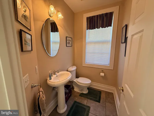 a bathroom with a sink toilet and a mirror