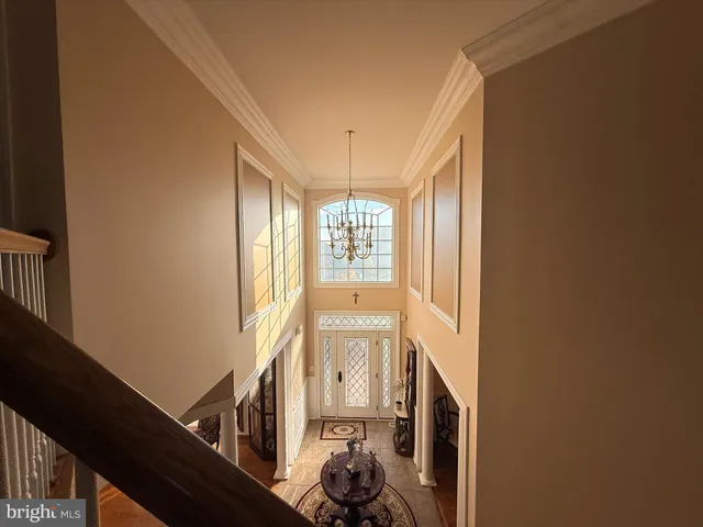 a view of a hallway with windows and chandelier
