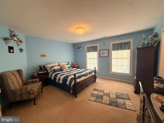 a bedroom with bed couch and window