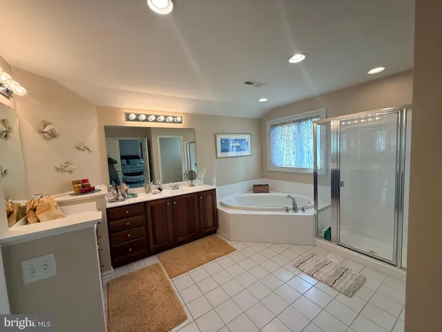 a spacious bathroom with a tub sink and mirror