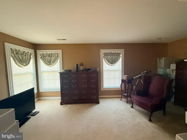 a living room with furniture and a air conditioner vent