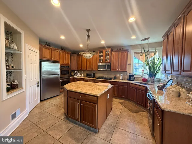 a kitchen with kitchen island granite countertop a sink counter top space appliances and cabinets