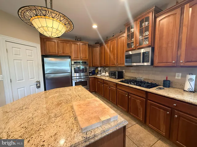 a kitchen with granite countertop a stove a sink and a microwave