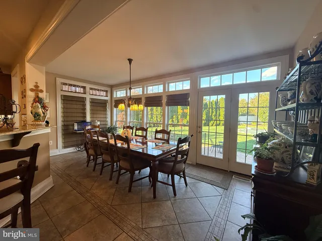 a dining room with furniture and large windows