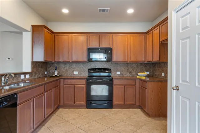 a kitchen with stainless steel appliances granite countertop a stove sink and cabinets