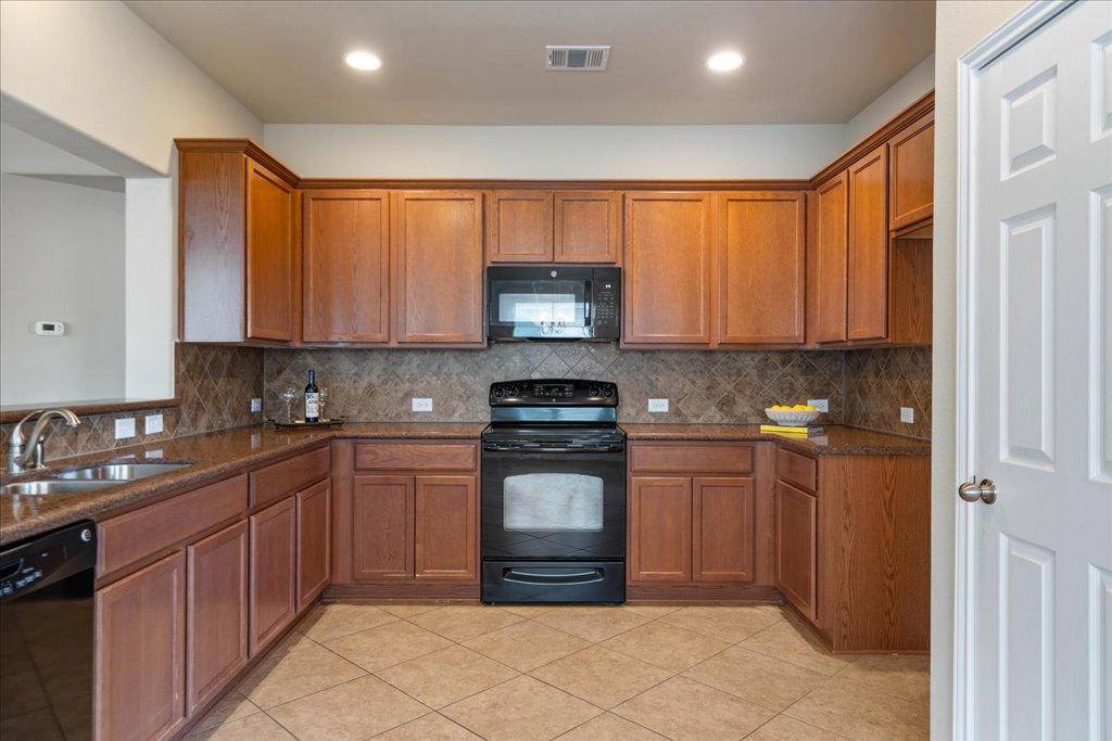 1810 Laminar Creek Road Cedar Park, TX 78613 - Photo 11 of 25 a kitchen with stainless steel appliances granite countertop a stove sink and cabinets