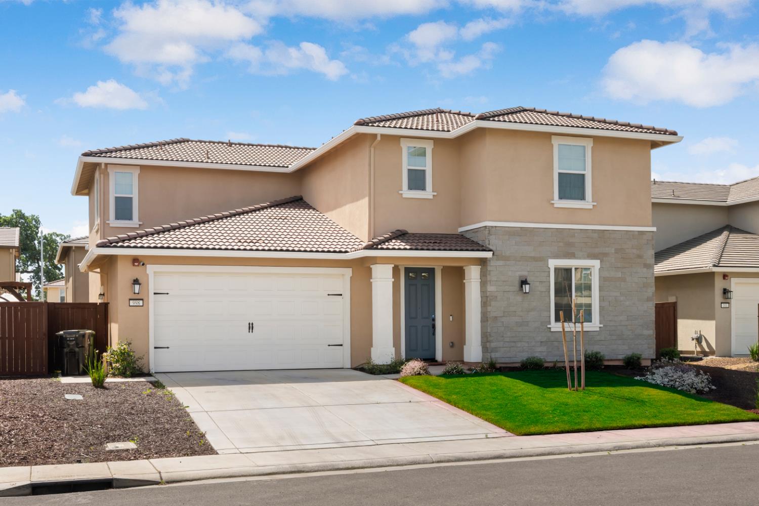 a front view of a house with a garden and garage