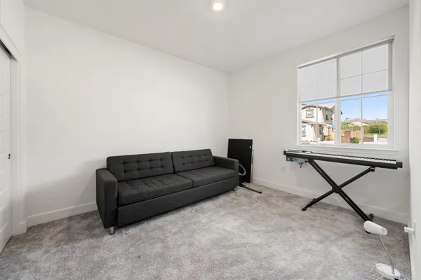 a living room with furniture and a piano