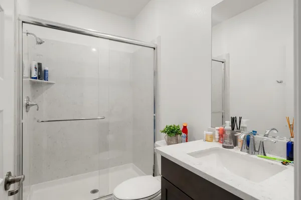 a bathroom with a sink vanity mirror and shower