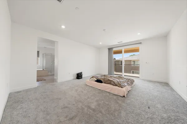 a large bed sitting in a room next to a window