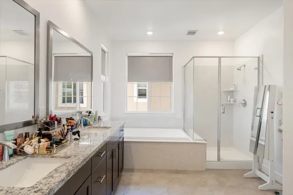 a bathroom with a granite countertop tub sink and mirror