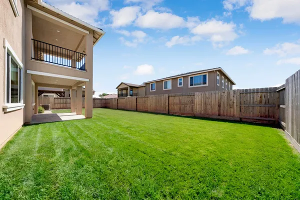 a view of a backyard with table and chairs and wooden fence