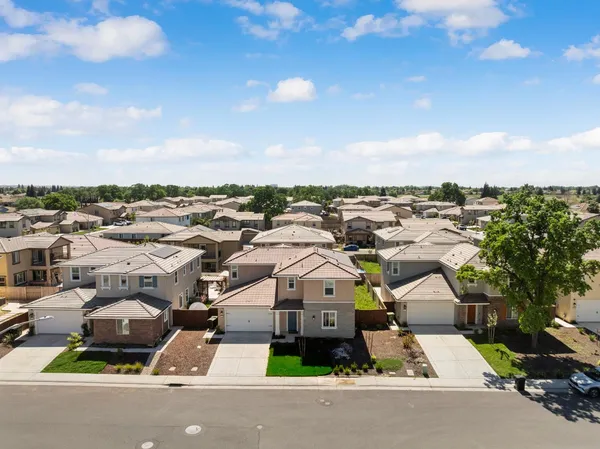 an aerial view of multiple houses with a street