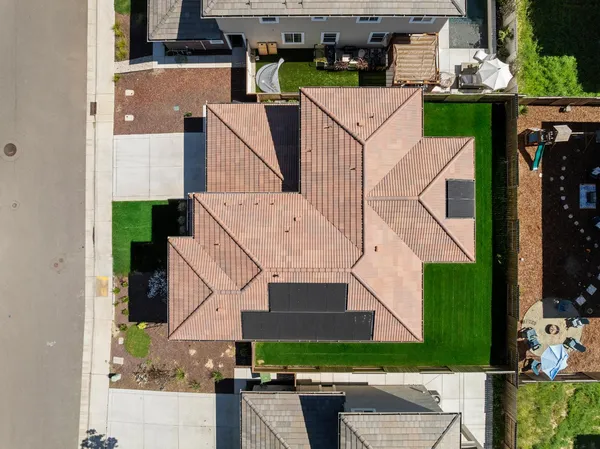 an aerial view of a house with a yard and a large tree