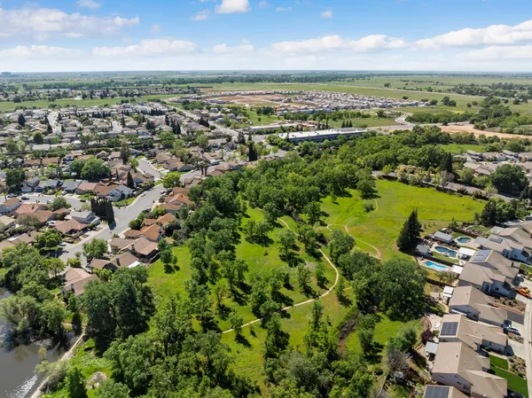an aerial view of a city with lots of residential buildings ocean and mountain view in back