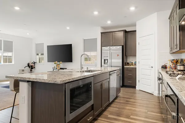 a kitchen with stainless steel appliances granite countertop a sink stove and refrigerator