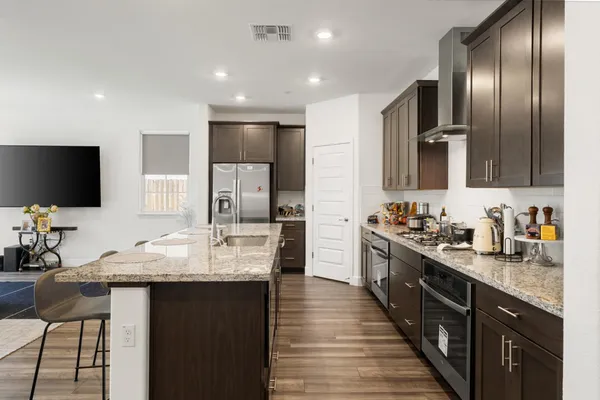 a kitchen with stainless steel appliances granite countertop a sink stove and refrigerator