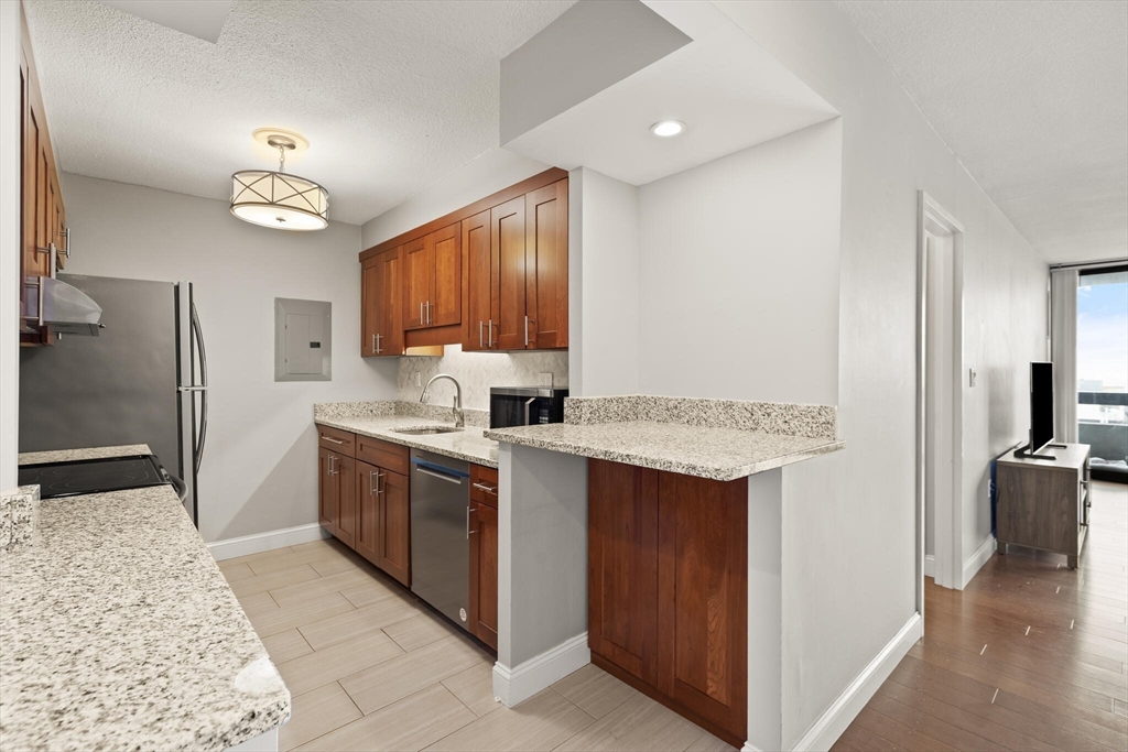 566 Commonwealth Avenue, Unit 1003 Boston, MA 02215 - Photo 3 of 14 a kitchen with a sink refrigerator and cabinets