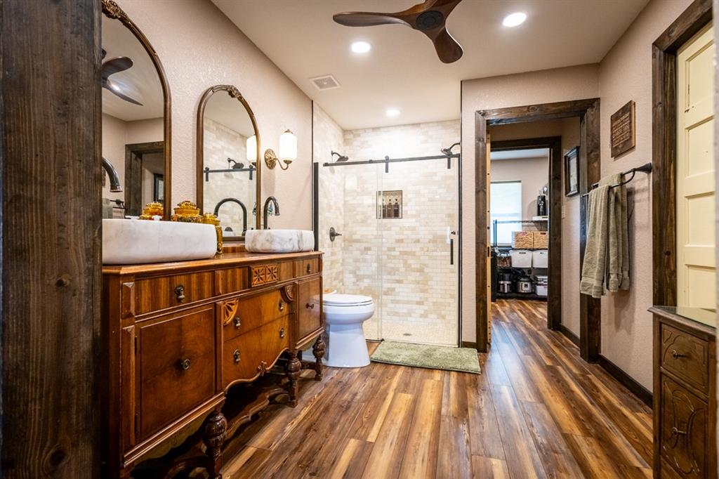 7060 Hells Gate Loop Strawn, TX 76475 - Photo 28 of 40 a bathroom with a double vanity sink toilet and shower