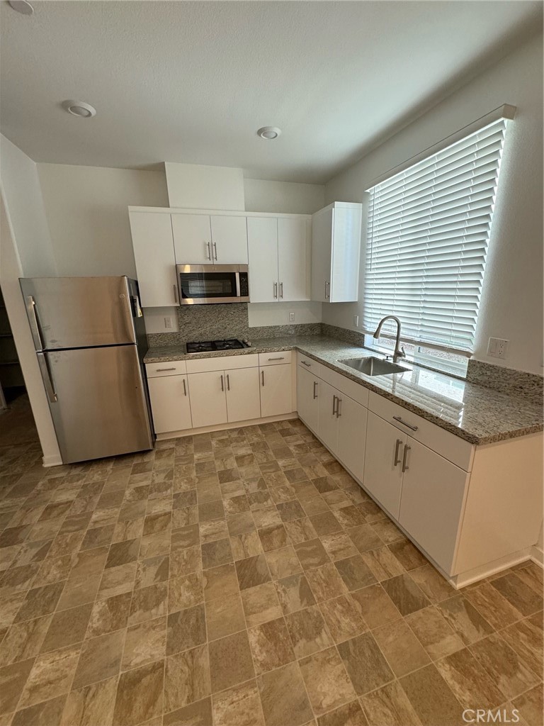 25685 Branson Lane Homeland, CA 92548 - Photo 4 of 13 a kitchen with sink cabinets and window