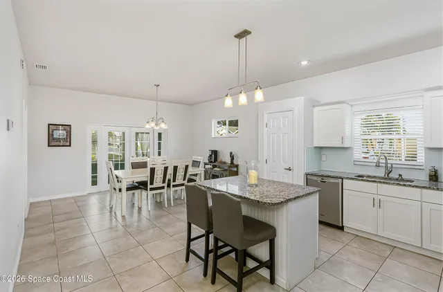 a kitchen with granite countertop sink table and chairs