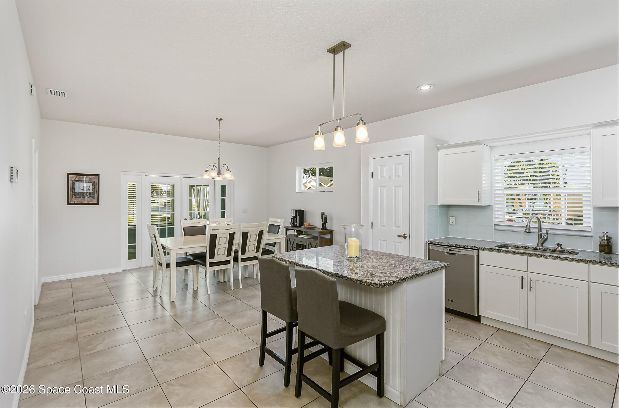 1069 South Fork Circle Melbourne, FL 32901 - Photo 14 of 52 a kitchen with granite countertop sink table and chairs