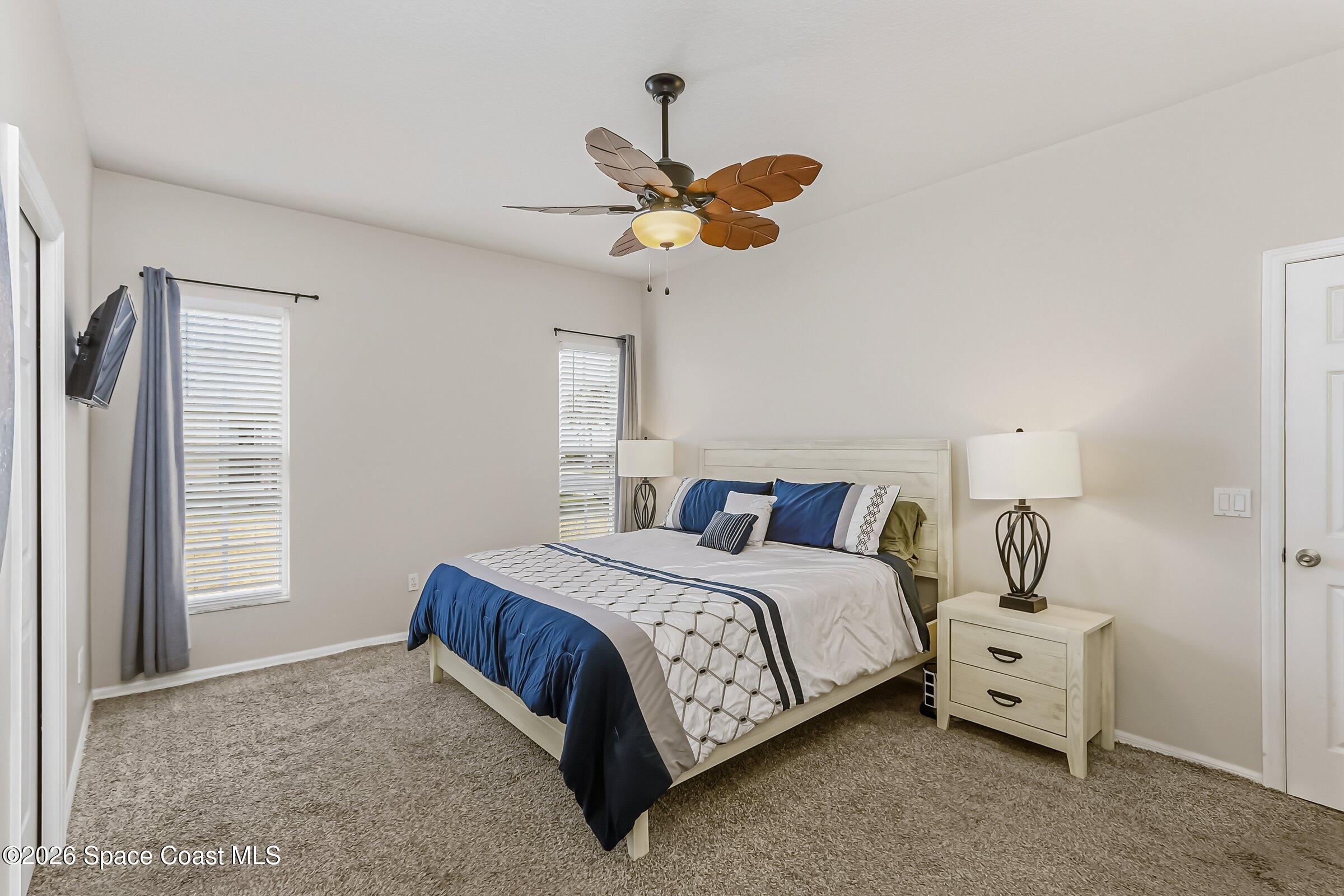 1069 South Fork Circle Melbourne, FL 32901 - Photo 18 of 52 a bedroom with a bed chandelier and a window