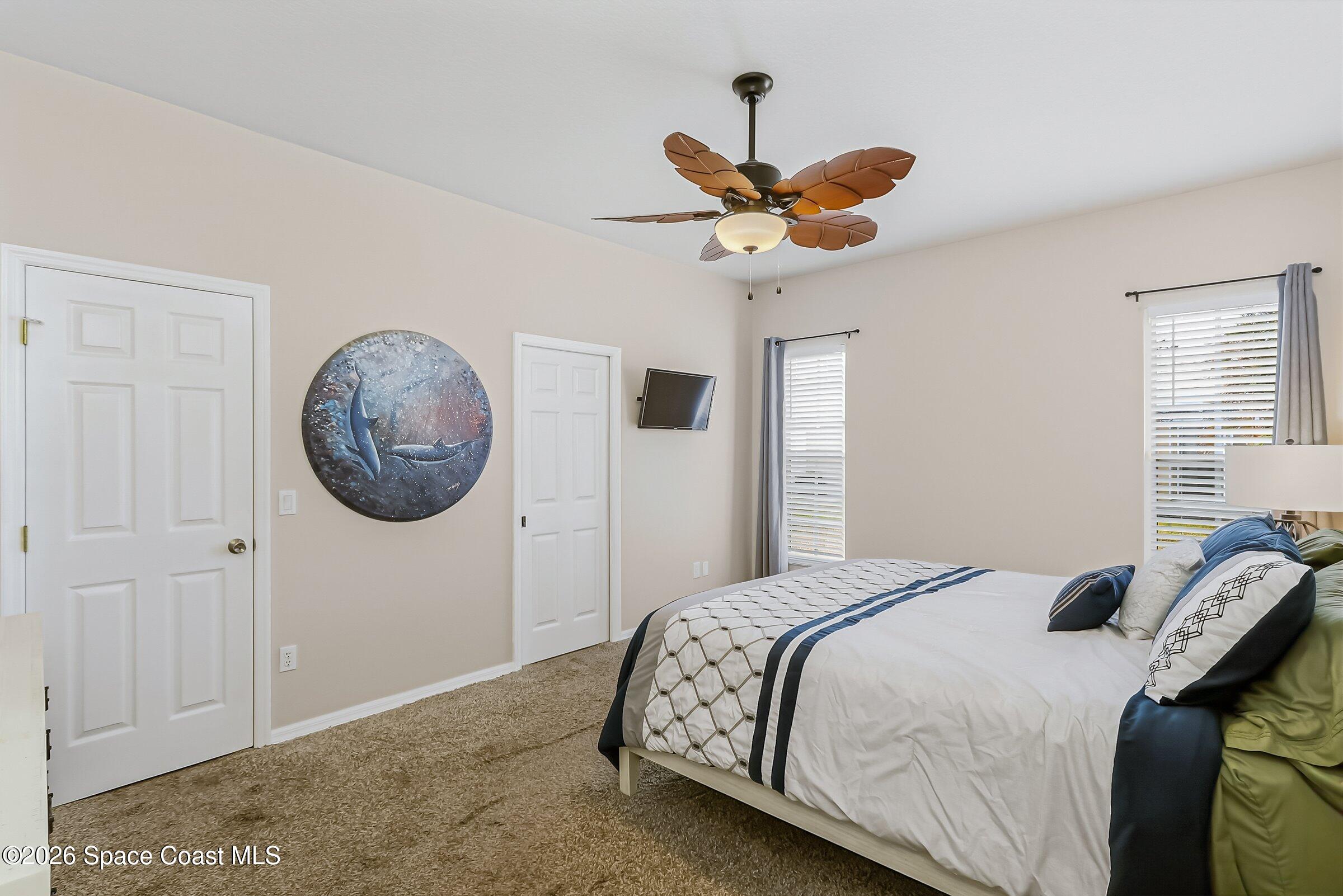 1069 South Fork Circle Melbourne, FL 32901 - Photo 19 of 52 a bedroom with a bed and a chandelier
