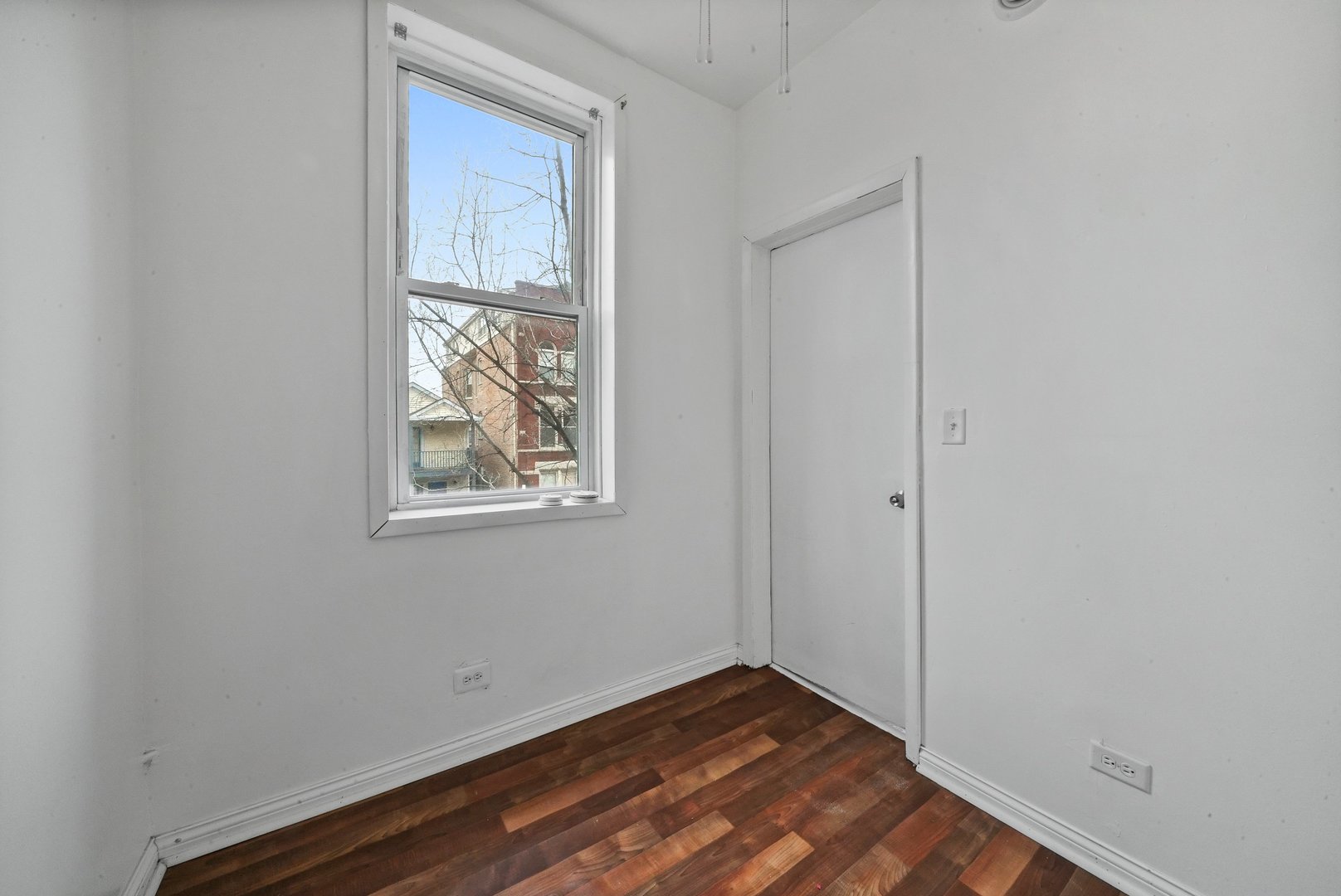 1154 West 17th Street Chicago, IL 60608 - Photo 12 of 35 a view of an empty room with window and wooden floor