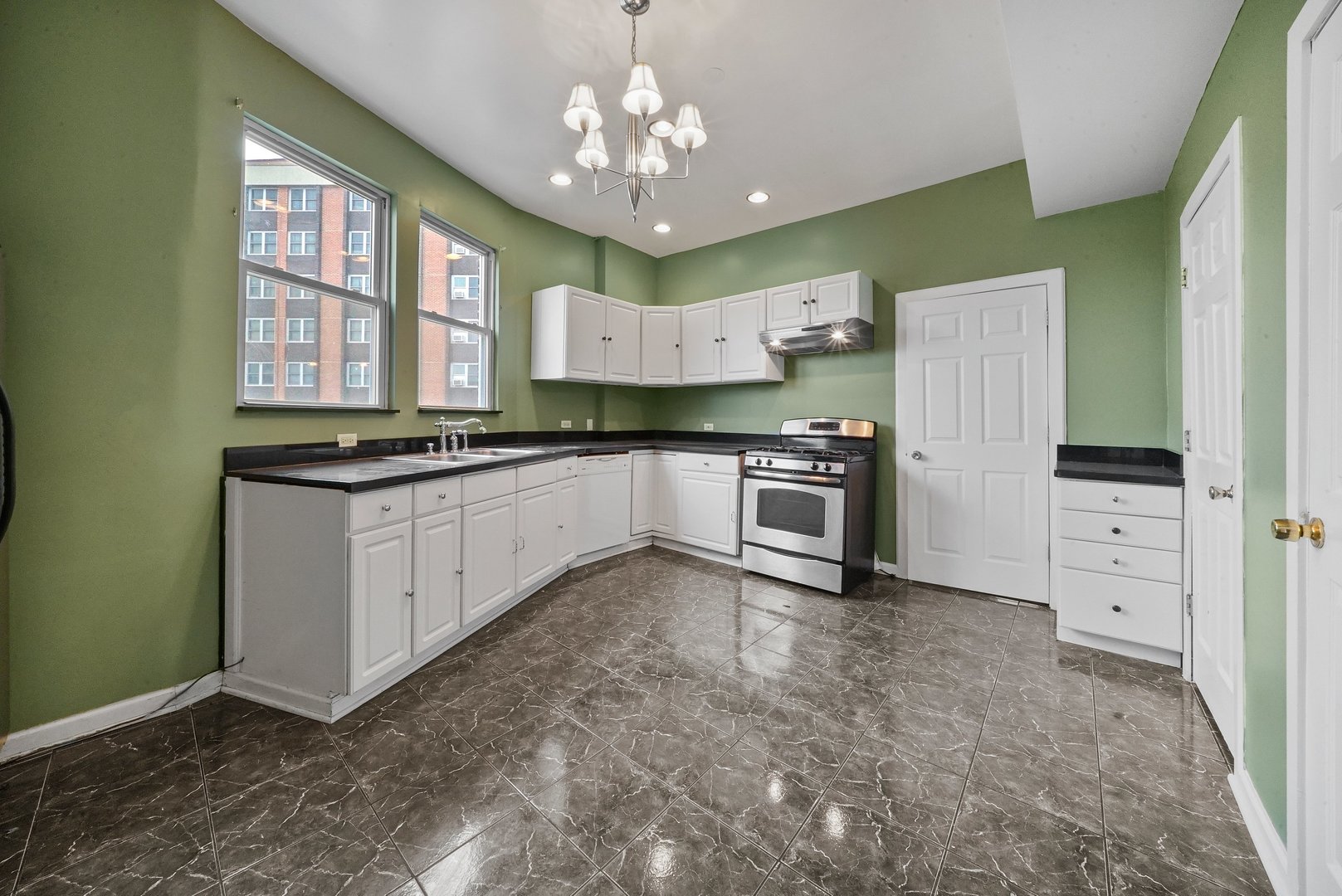 1154 West 17th Street Chicago, IL 60608 - Photo 22 of 35 a kitchen with stainless steel appliances granite countertop a stove sink and cabinets