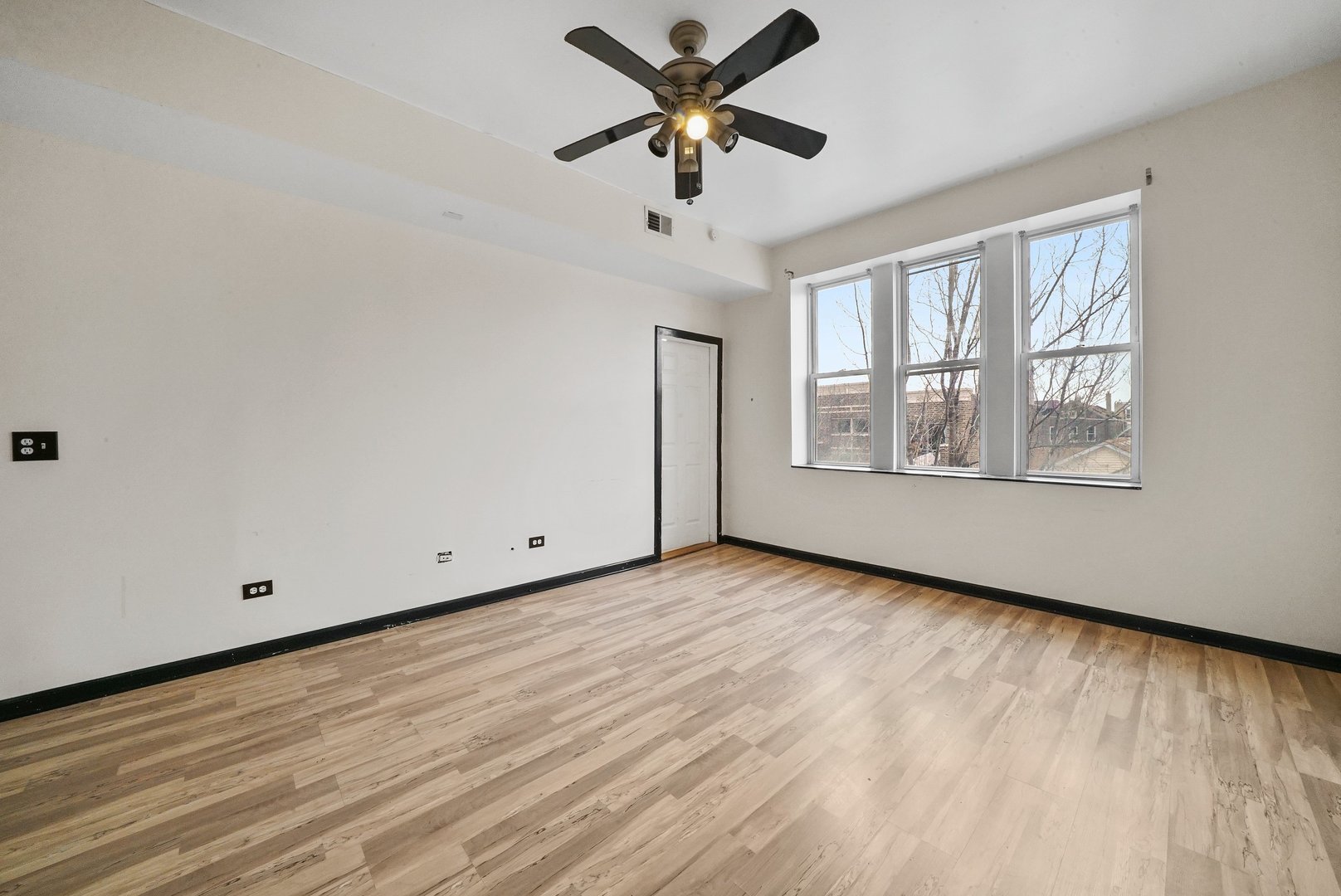 1154 West 17th Street Chicago, IL 60608 - Photo 25 of 35 an empty room with wooden floor chandelier fan and windows