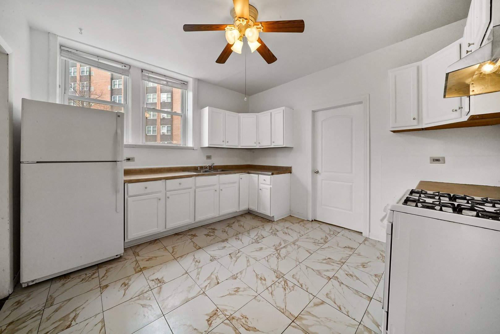 1154 West 17th Street Chicago, IL 60608 - Photo 10 of 35 a kitchen with white cabinets and white appliances